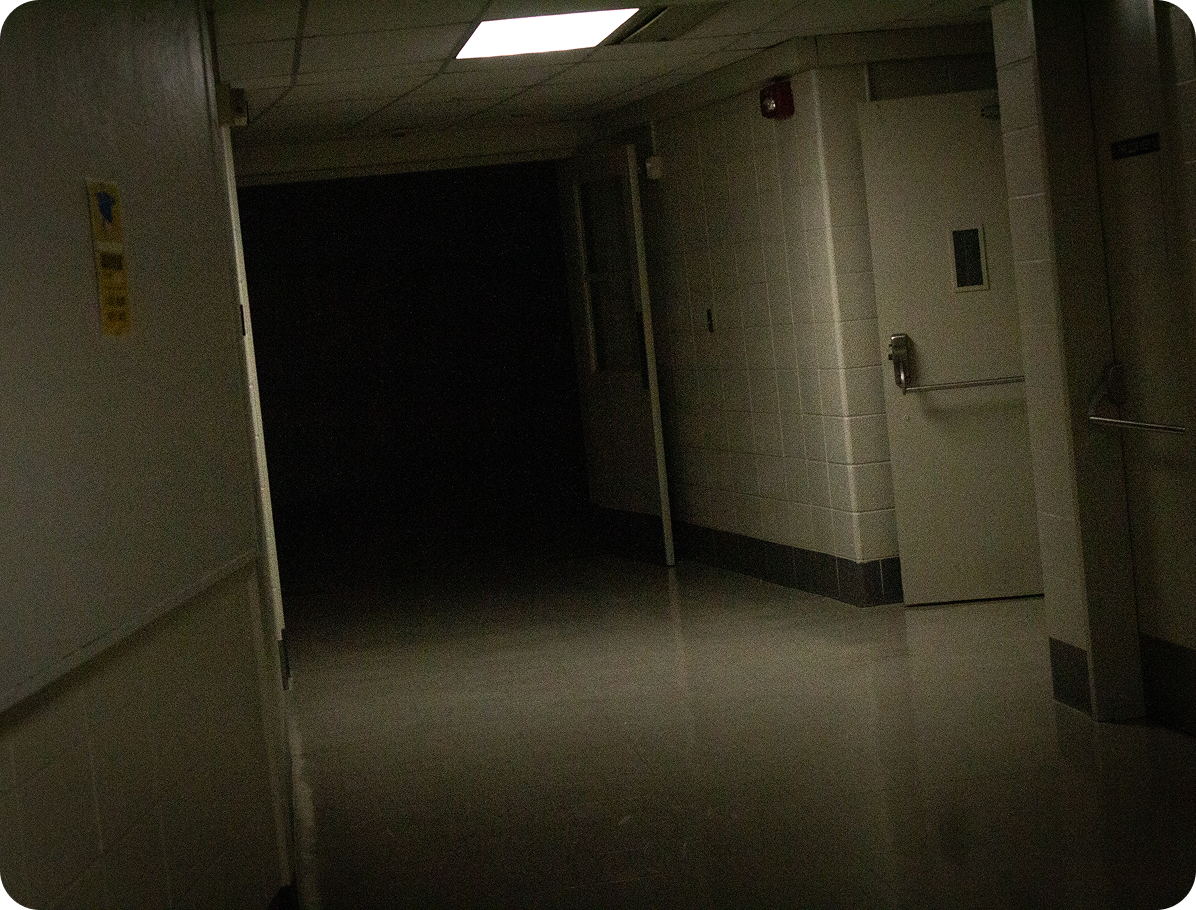 dimly lit hallway fading into a pitch black hallway