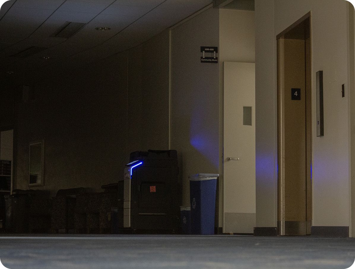 dark hallway with the only light coming from a printer and a stairwell
