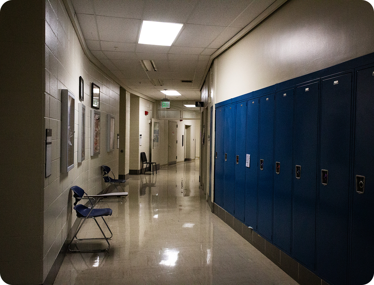 dimly lit hallway with desks, curving into the wall giving the feeling of an infinite hall