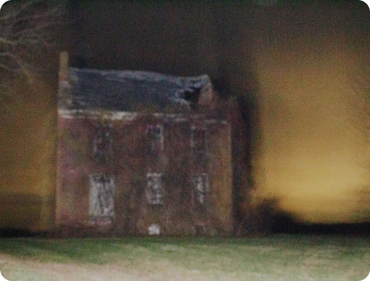 old run down brick house with vines growing all over it in front of a deep yellow sky