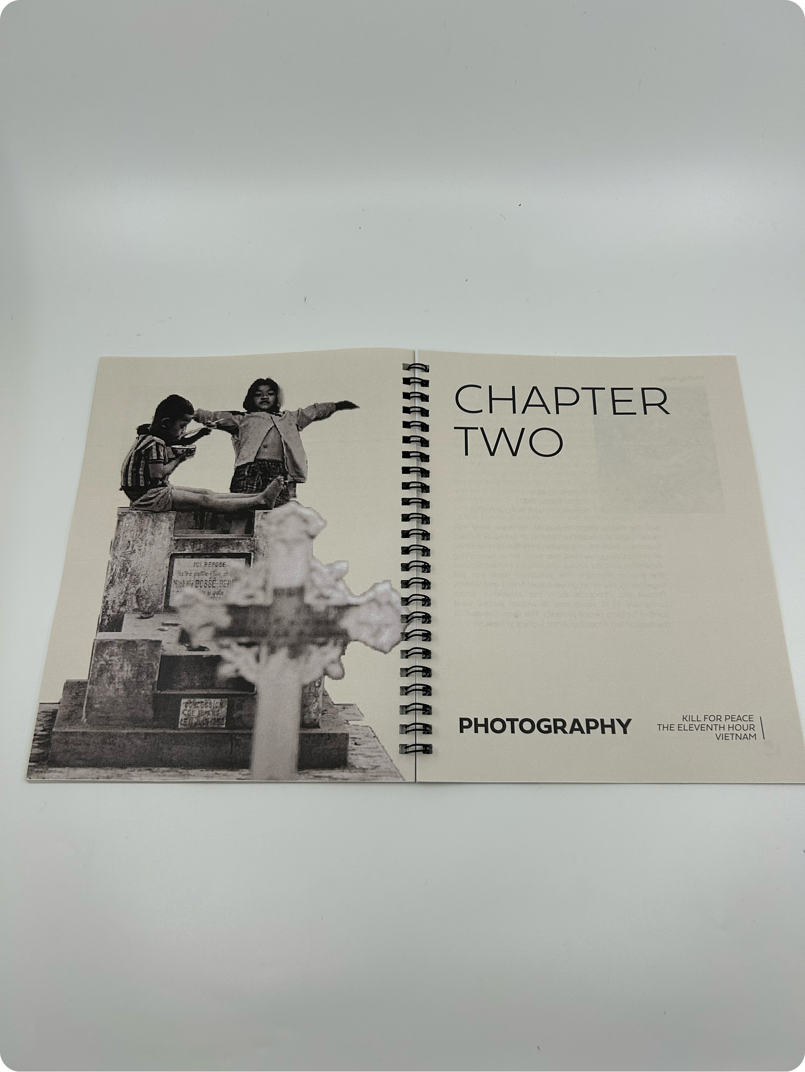 Catalog book opened to the chapter 2 title page containing a photograph of kids at a grave