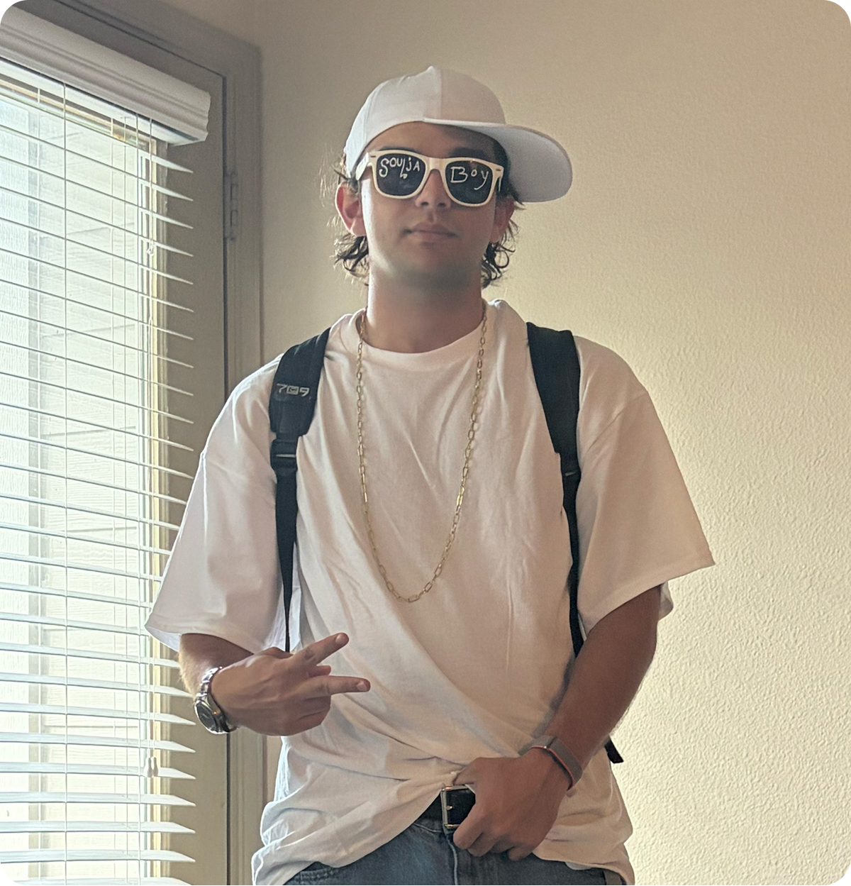 Guy dressed up in a white t-shirt, sunglasses, and hat